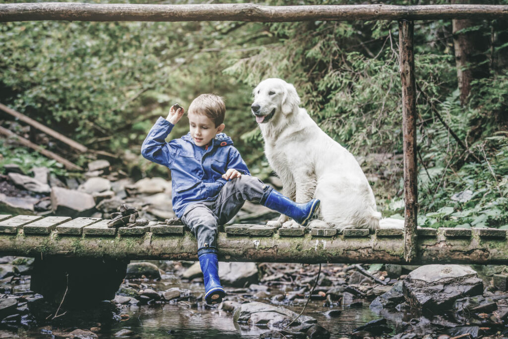 Kind mit Hund auf Brücke Sommer | Familien-Chaleturlaub in Schröcken