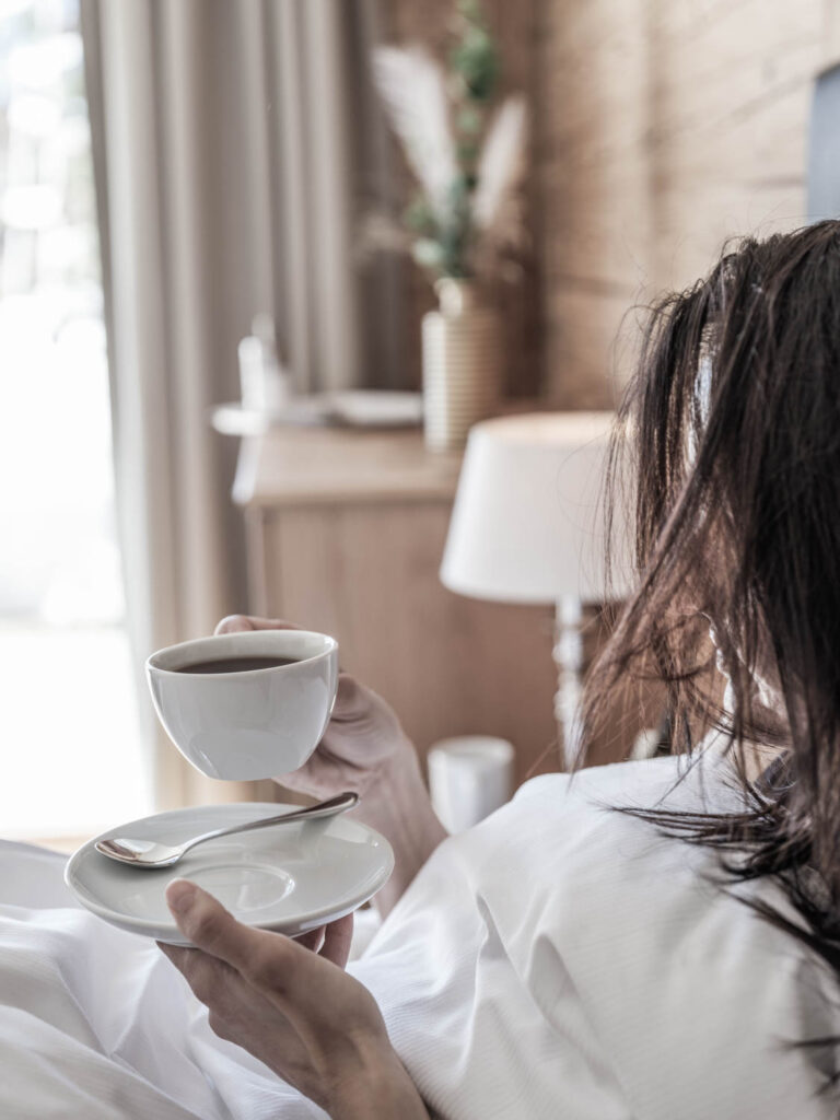 Frau trinkt Kaffee im Bett