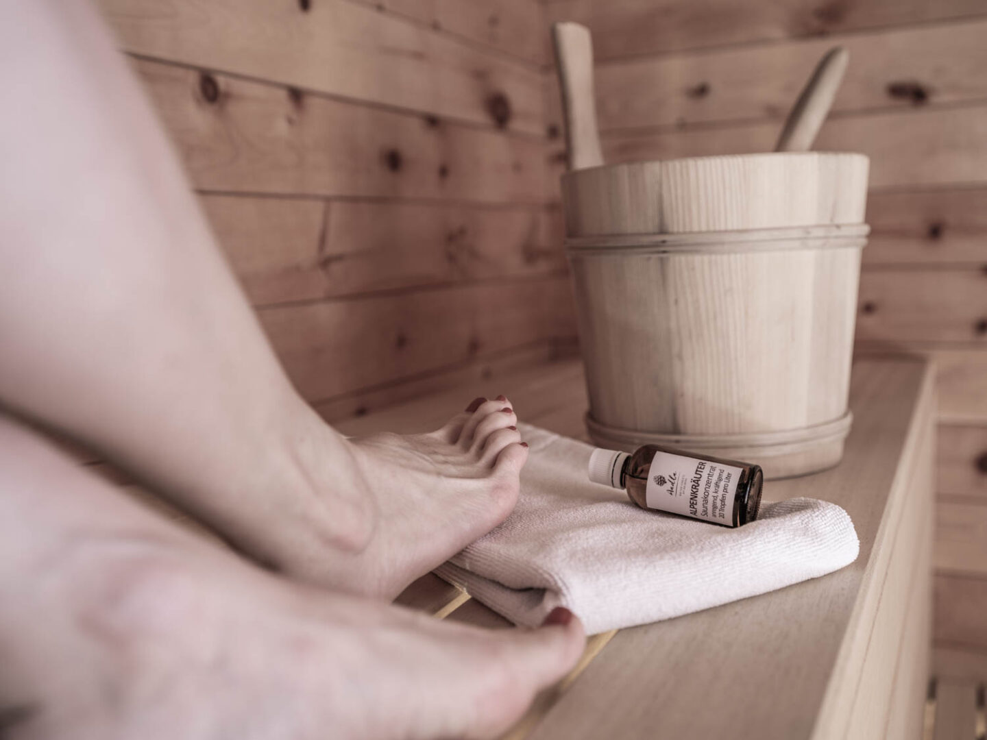 nackte Füße in Sauna mit Saunazubehör Hintergrundbild | Chalet mit Sauna am Arlberg