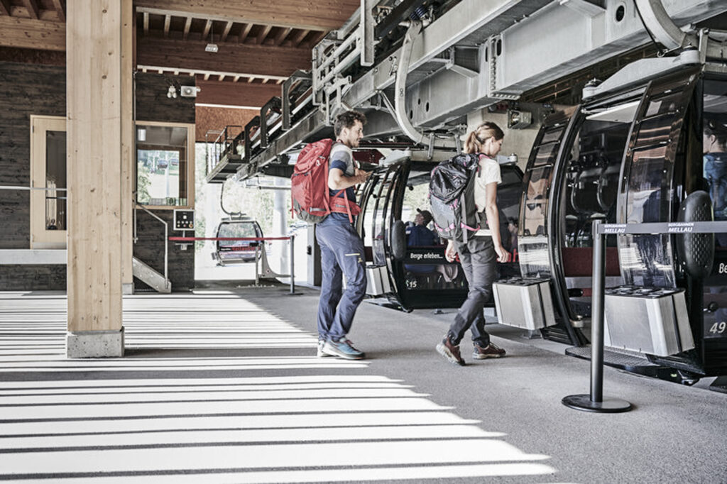 Wanderer steigen in Bergbahn ein | Sommerurlaub im Bregenzerwald