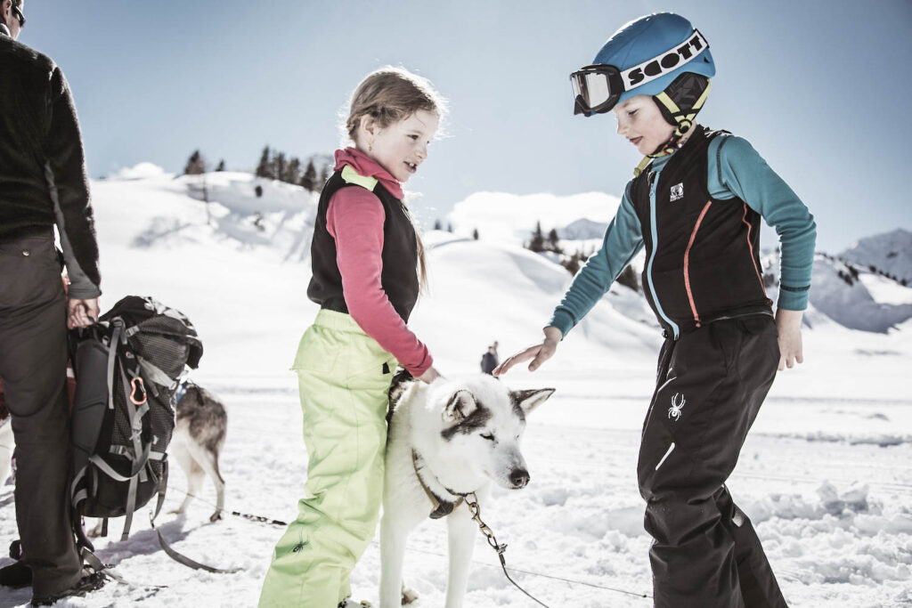 Kinder spielen mit Huskys | Skiurlaub mit Kindern am Arlberg