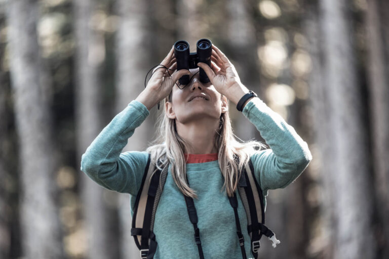 Frau schaut durch Fernglas