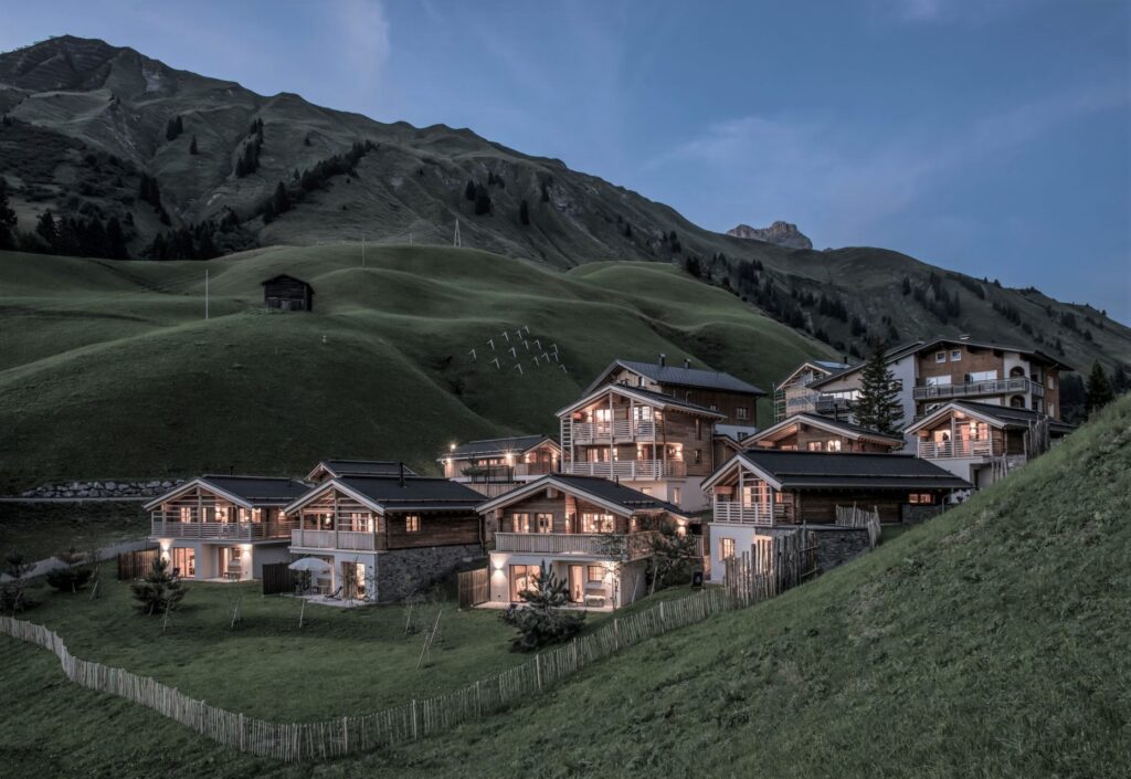 Chalets mit leuchtenden Fenstern in Dämmerung
